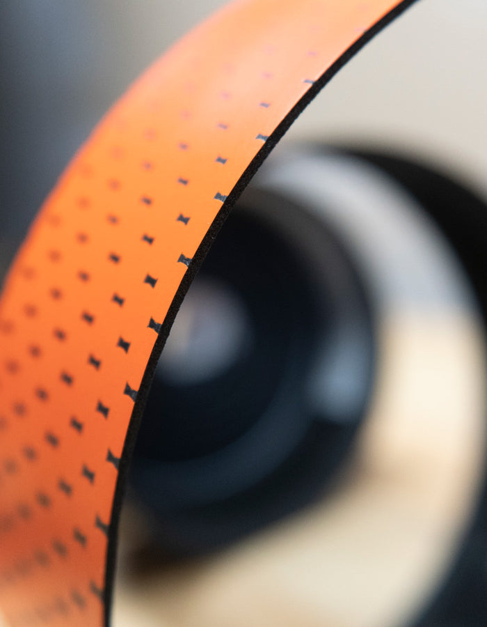 Close-up of a bicycle bar tape with orange and blurred background